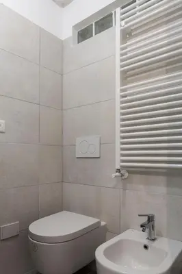 a white bathroom with a toilet and a sink at A due passi dal Colosseo in Rome