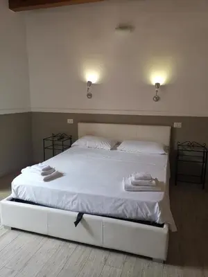 a bedroom with a white bed with two towels on it at I love Colosseo in Rome