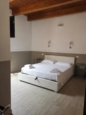 a large white bed in a room with a wooden floor at I love Colosseo in Rome