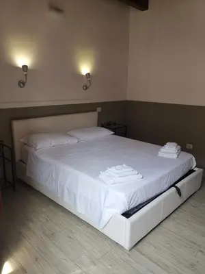 a bedroom with a white bed with towels on it at I love Colosseo in Rome