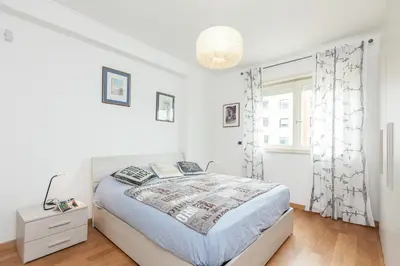 a white bedroom with a bed and a window at Boutique Domus River Terrace in Rome