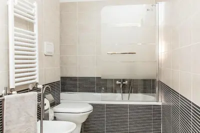a bathroom with a toilet and a tub and a sink at Boutique Domus River Terrace in Rome