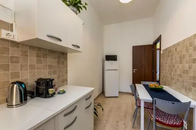 a kitchen with a table with chairs and a refrigerator at Italia Room vicino Stazione Termini in Rome