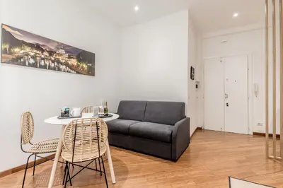 a living room with a couch and a table and chairs at Sweethome Marconi in Rome