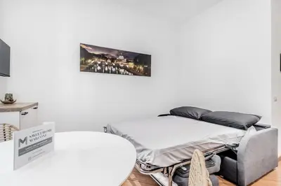 a bed in a room with a white wall at Sweethome Marconi in Rome