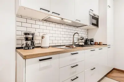 a kitchen with white cabinets and a sink at Sweethome Marconi in Rome
