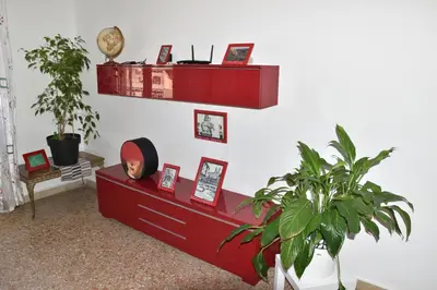 a living room with a red dresser and a plant at Aura Home Grazioso Appartamento a Pochi Passi dalla Metro A e C in Rome