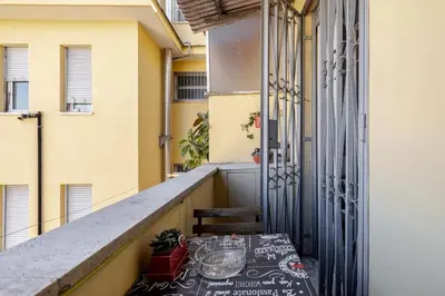 a table on the balcony of a building at Aura Home Grazioso Appartamento a Pochi Passi dalla Metro A e C in Rome