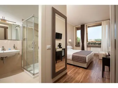 a hotel room with a bed and a sink and a shower at Window On Rome in Rome