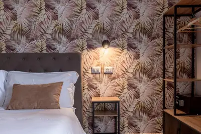 a bedroom with a bed and a shelf with hangers at Affittacamere Casalí in Rome