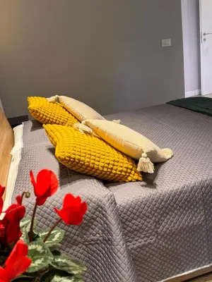 a bed with corn on it with red flowers on it at GetRoma apartment Vatican Museum in Rome