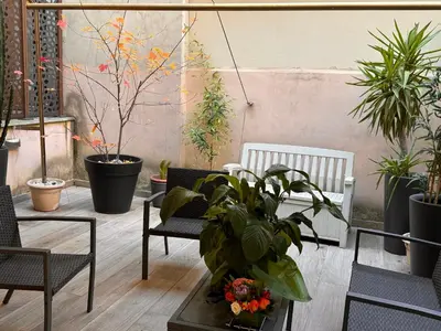 a patio with plants and chairs and a table at GetRoma apartment Vatican Museum in Rome