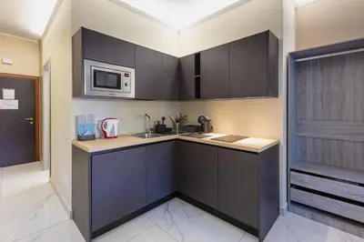 a kitchen with black cabinets and a microwave at Aurelia Boutique Apartment in Rome