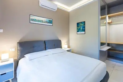 a bedroom with a white bed with a blue headboard at Aurelia Boutique Apartment in Rome