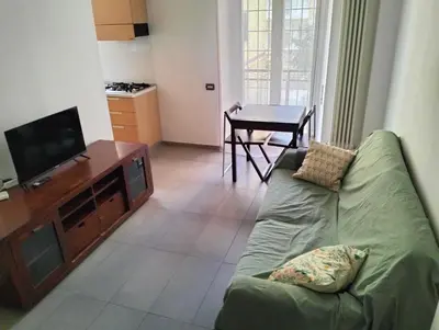 a living room with a green couch and a television at Appartamento Monteverde in Rome