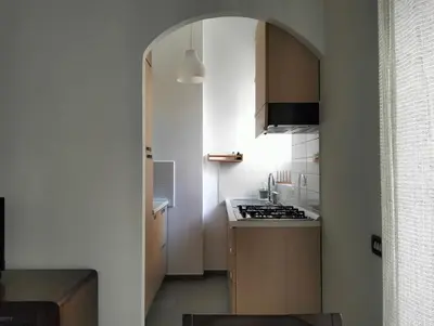 a small kitchen with an archway leading to a stove at Appartamento Monteverde in Rome