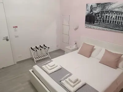 a bedroom with a large white bed with pink pillows at B&B VIKTORIA in Rome