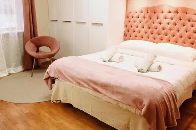 a bedroom with a large bed with a pink headboard at Chic and Elegant Apartment in the heart of Rome in Rome