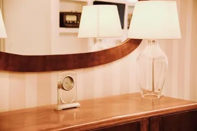 a table with a lamp and a clock on it at Chic and Elegant Apartment in the heart of Rome in Rome