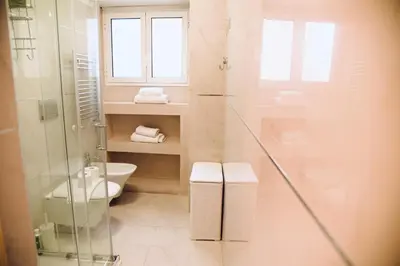 a bathroom with a toilet and a glass shower at Chic and Elegant Apartment in the heart of Rome in Rome