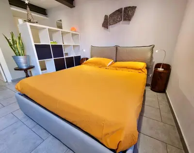 a bedroom with a large bed with yellow sheets at Poetico Monolocale Indipendente nell’Antico Pastificio in Rome