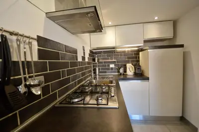 a kitchen with a stove and a sink in it at Poetico Monolocale Indipendente nell’Antico Pastificio in Rome