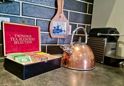 a tea kettle on a counter with a box of tea benefits selection at Poetico Monolocale Indipendente nell’Antico Pastificio in Rome