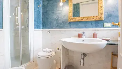 a bathroom with a sink and a toilet and a mirror at EasyTopStay - Colonna Guest House in Rome