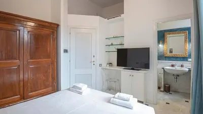 a bedroom with a bed and a sink and a tv at EasyTopStay - Colonna Guest House in Rome