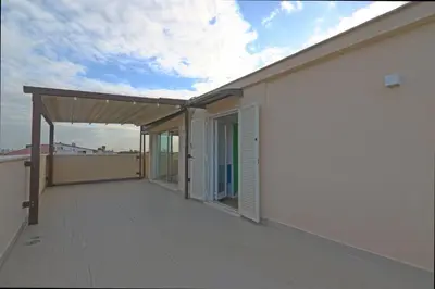 an empty balcony of a white building with a roof at Angela attico a pochi minuti dal Gemelli e Stazione FL3 direzione San Pietro - Roma centro in Rome