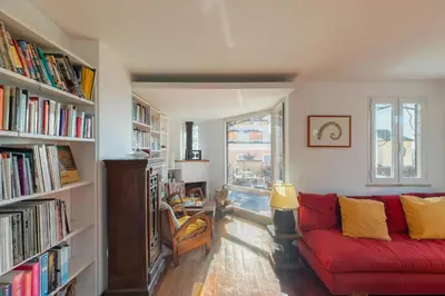 a living room with a red couch and shelves of books at iFlat Orient in Rome in Rome