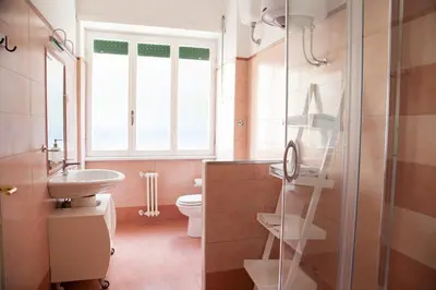 a bathroom with a sink and a toilet and a window at Cicerone 60 in Rome