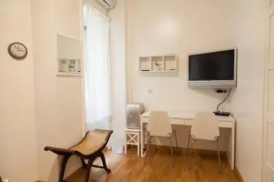 a room with a desk with chairs and a tv on the wall at Cicerone 60 in Rome