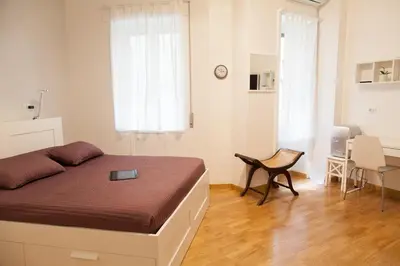 a bedroom with a bed and a table and chairs at Cicerone 60 in Rome