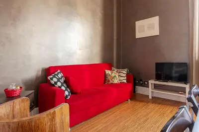 a red couch in a living room with a tv at GuestHost - Roma Termini Lovely Apartment in Rome