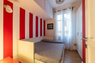 a bedroom with a bed with red and white stripes at GuestHost - Roma Termini Lovely Apartment in Rome