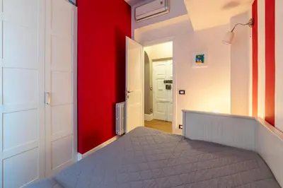 a bedroom with red and white walls and a bed at GuestHost - Roma Termini Lovely Apartment in Rome