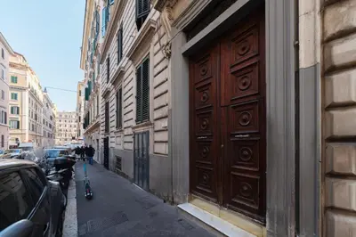 a building with a large wooden door on the side of a street at GuestHost - Roma Termini Lovely Apartment in Rome