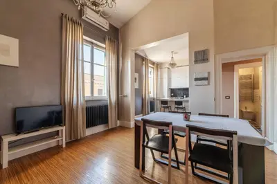 a dining room with a table and chairs and a television at GuestHost - Roma Termini Lovely Apartment in Rome