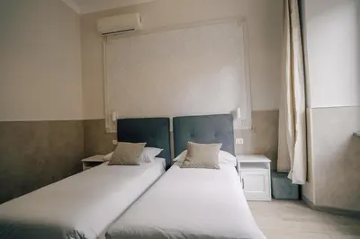 two beds in a small room with twoermottermottermott at Mirabilia House in Rome