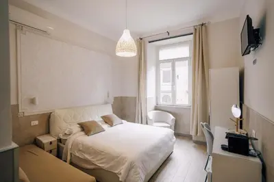 a bedroom with a white bed and a window at Mirabilia House in Rome