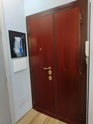 a wooden door in a room with a picture on the wall at SPQR Luxury Appartments - Stazione Trastevere in Rome
