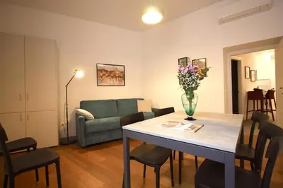 a living room with a table with a vase of flowers on it at Risorgimento Holiday Home in Rome