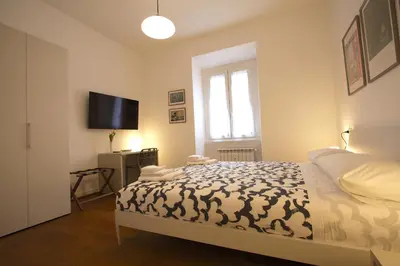 a bedroom with a bed and a flat screen tv at Risorgimento Holiday Home in Rome