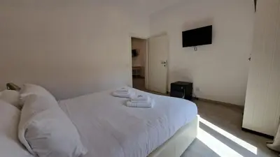 a bedroom with a white bed with towels on it at Major 93 Guesthouse in Rome
