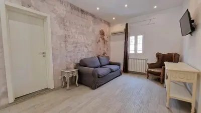 a living room with a blue chair and a table at Major 93 Guesthouse in Rome