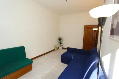 a living room with a blue couch and a lamp at Blue Vatican House in Rome