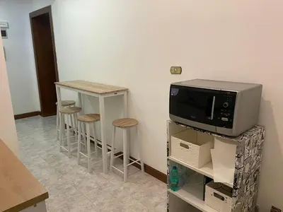 a kitchen with a microwave and two bar stools at Blue Vatican House in Rome