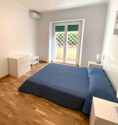 a bedroom with a blue bed and a window at Vacanze Romane in Rome