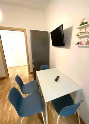 a room with a white table and blue chairs at Vacanze Romane in Rome